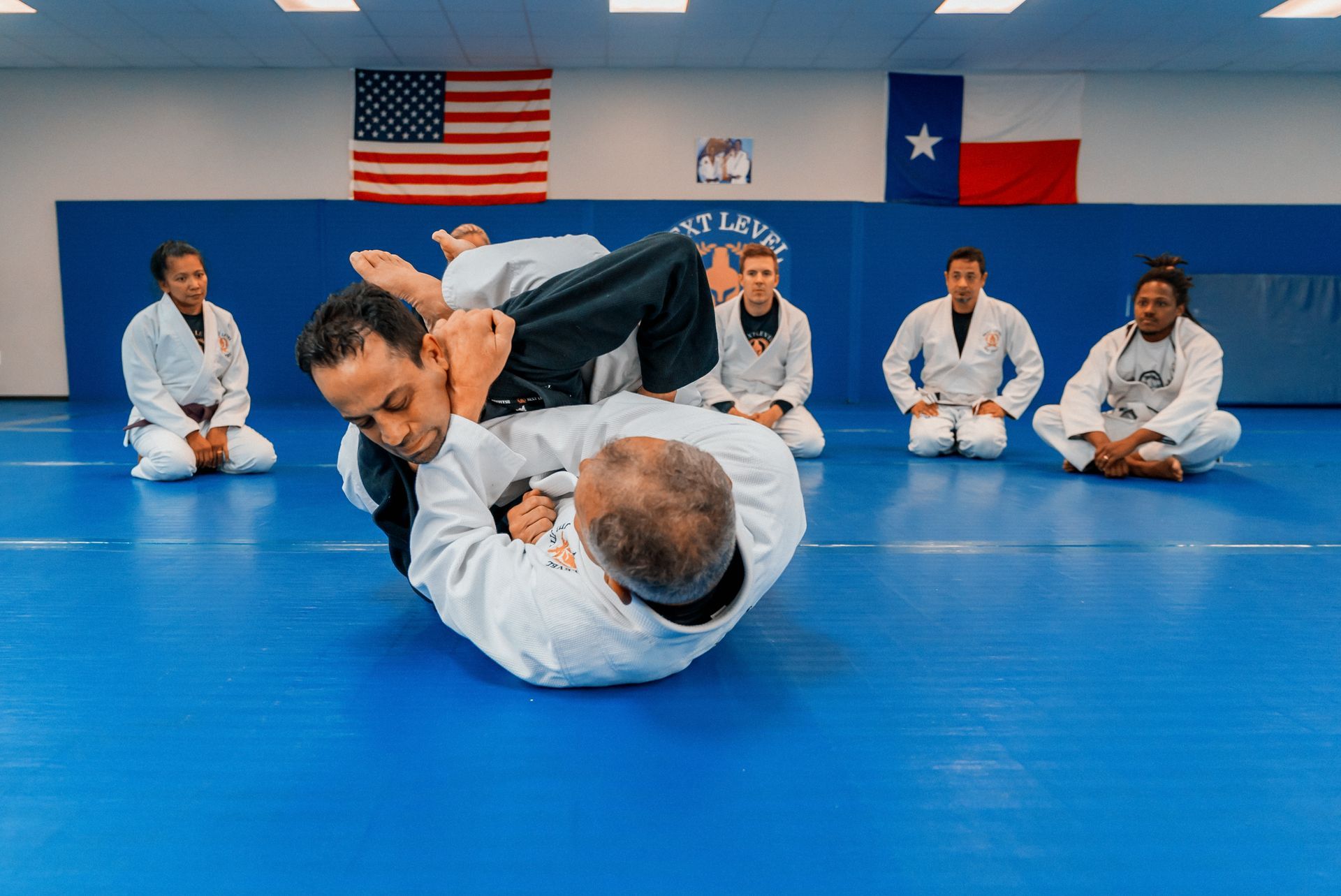 Coach instructing young students during a beginner jiu jitsu class